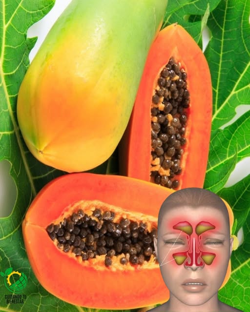 Papayas enteras y cortadas sobre hojas